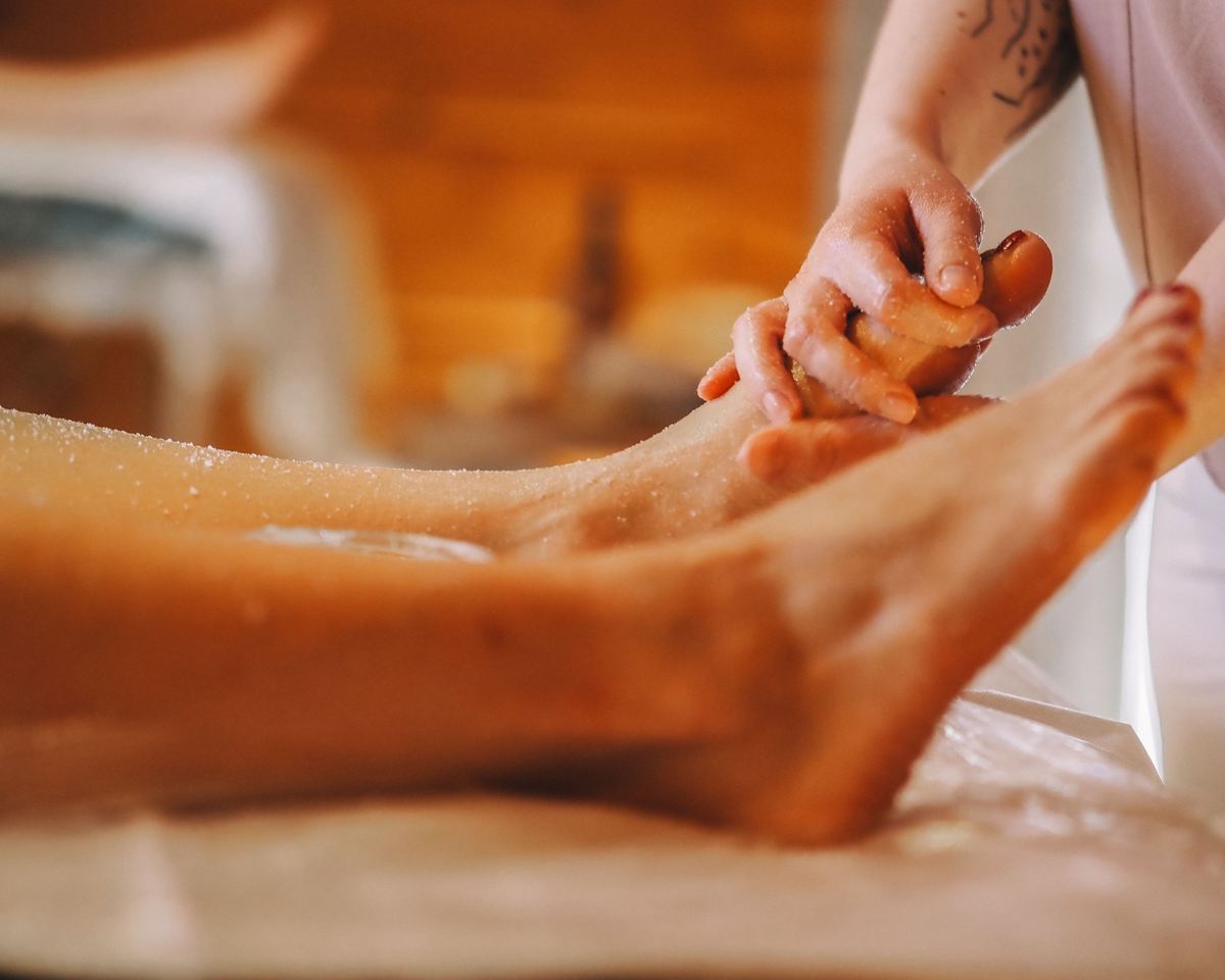 Both hands working through the muscles of a client's foot